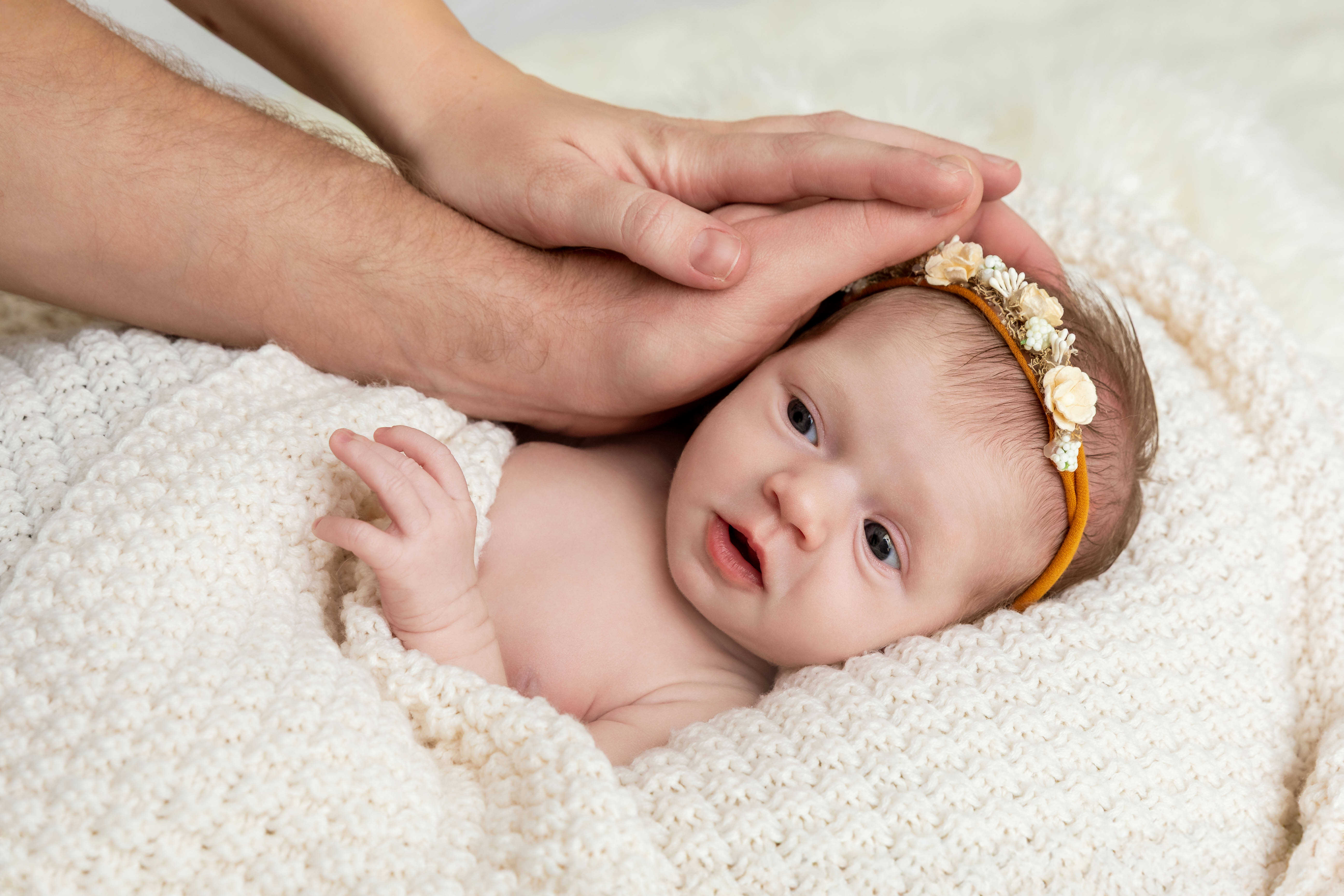 Newborn focení Brno, novorozené miminko s květinovou čelenkou a viditelnou tváří v ateliéru v Čechyni nedaleko Brna, jemné přírodní tóny