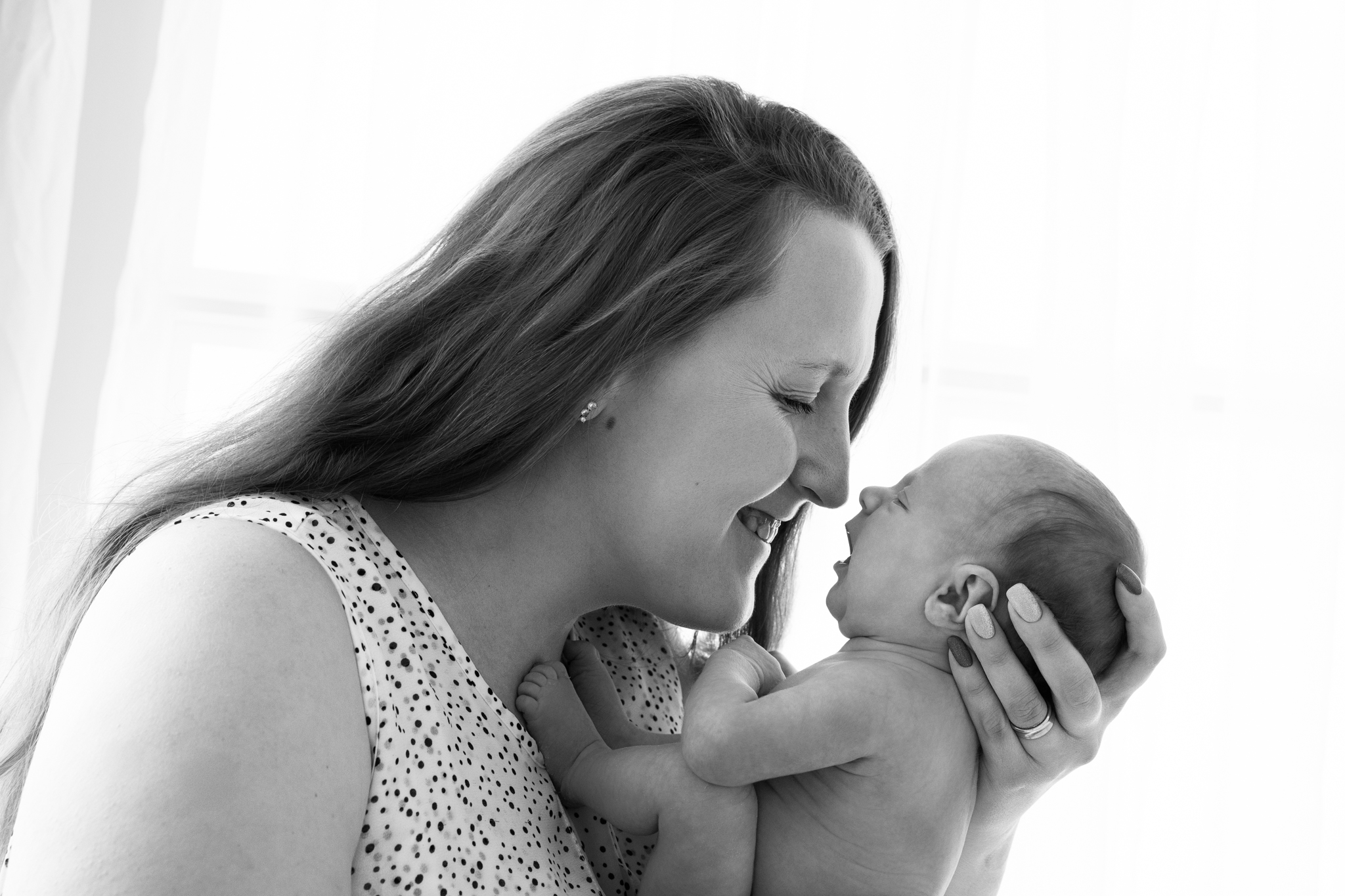Newborn focení Brno, černobílý portrét maminky držící novorozené miminko v náručí v ateliéru v Čechyni nedaleko Brna, jemné přirozené světlo