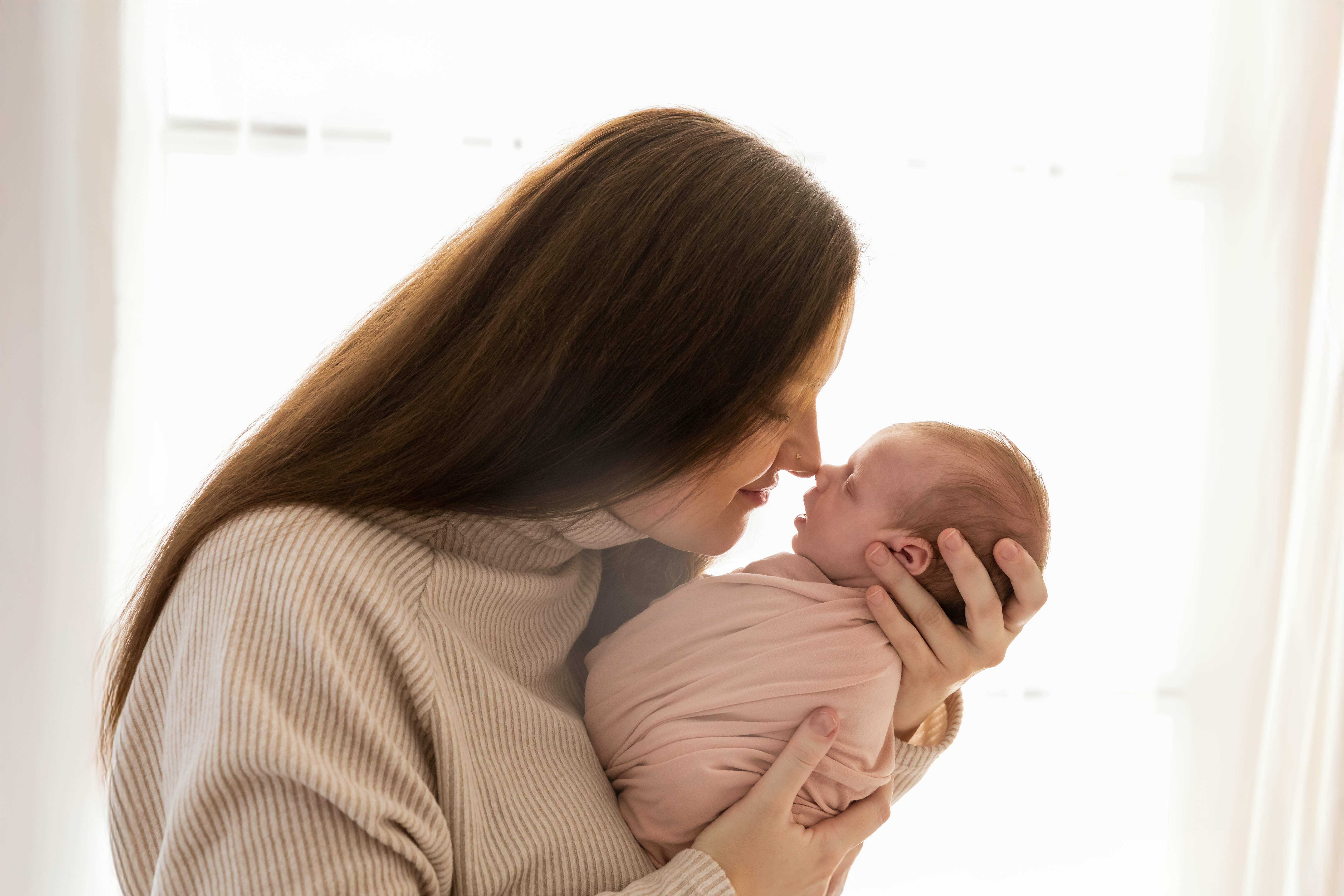 Newborn focení Brno, maminka drží novorozené miminko v náručí při rodinném focení v ateliéru v Čechyni nedaleko Brna
